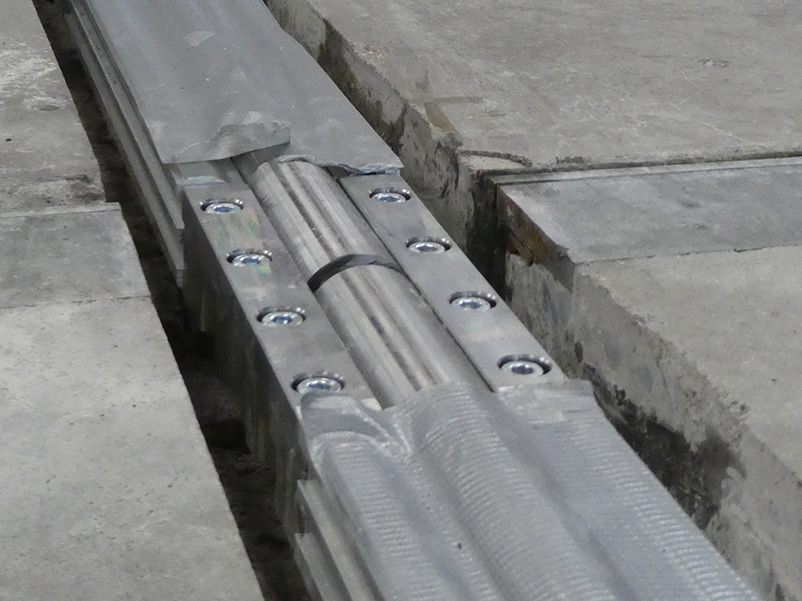 Close-up of a transition piece with an expansion joint in a floor-integrated guide rail.