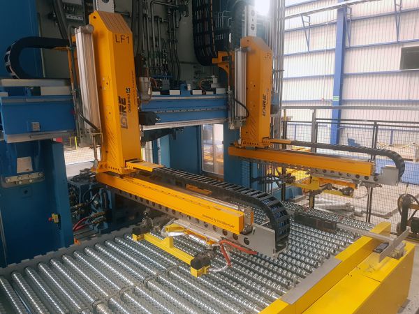 Schrägansicht eines Pressentransfers mit Greifertraverse über dem Materialtransportbereich.