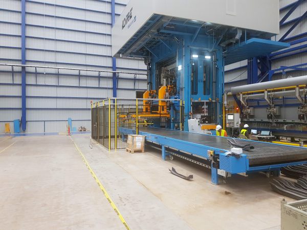 Schrägansicht eines End-of-Line-Auslaufbands. Das Förderband transportiert die pressgehärteten Bauteile vom Pressenbereich zur nachgelagerten Weiterverarbeitung.