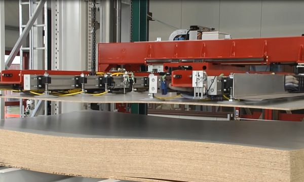 Detailansicht einer Saugtraverse über einem Plattenstapel. Die Saugelemente sind abgesenkt und liegen zur Aufnahme der obersten Platte auf dem Material auf.