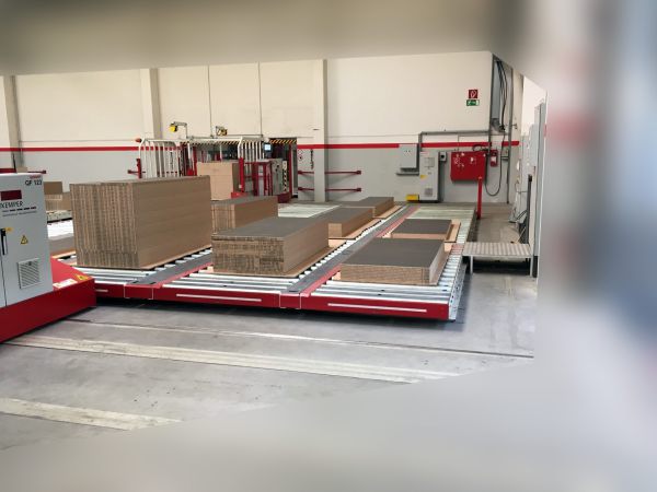 Gesamtansicht eines Pufferspeichers mit mehreren Materialstapeln auf Rollenförderstrecken. Die Stapel sind auf verschiedenen Pufferplätzen innerhalb der Anlage bereitgestellt.