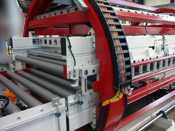 Industrielle Trommelwender mit mehreren grauen Walzen und rotem Rahmen in Produktionsumgebung