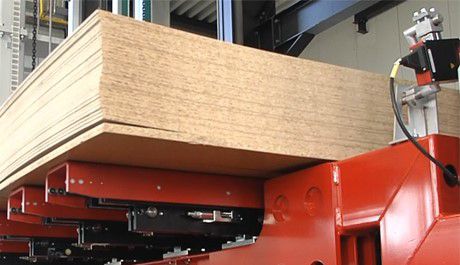 Mehrere übereinanderliegende, durch den Trommelwender ausgerichtete Holzplatten 
