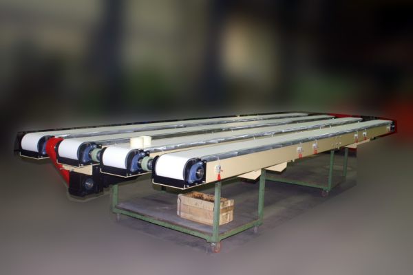 Vier parallel angeordnete Auslaufbänder mit presswerksgerechter Konstruktion und robustem Metallgestell in einer Halle
