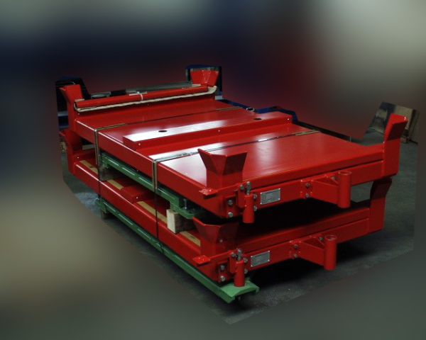 Roter Stapelwagen mit flacher Ladefläche und seitlichen Halterungen auf dunklem Hintergrund