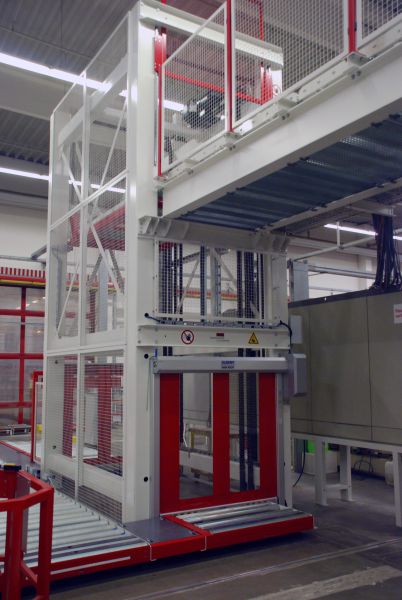 Hubstation mit Förderband und Sicherheitsgitter in einer Industriehalle