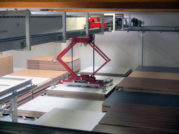 Detailansicht eines Handlingsystems mit Scherenhubmechanik. Der Greifer ist über einem Plattenstapel positioniert und für die Materialaufnahme abgesenkt.