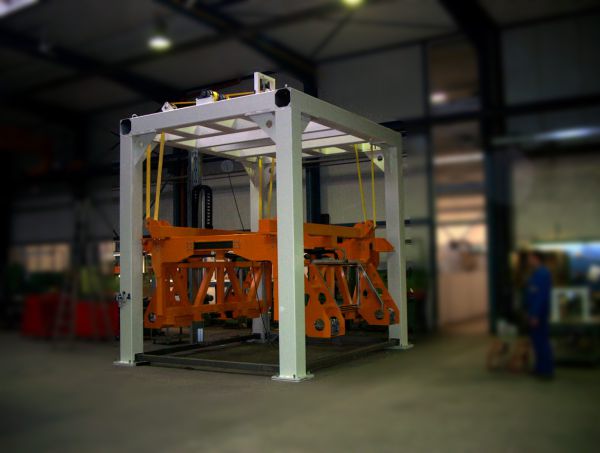 Schrägansicht eines Stapel-Dopplers. Die orangefarbene Hub- und Positioniereinheit befindet sich innerhalb des Maschinenrahmens in abgesenkter Position.