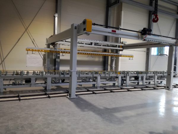 Große industrielle Portal-Feedersystemanlage mit gelbem Steuergerät in einer Halle