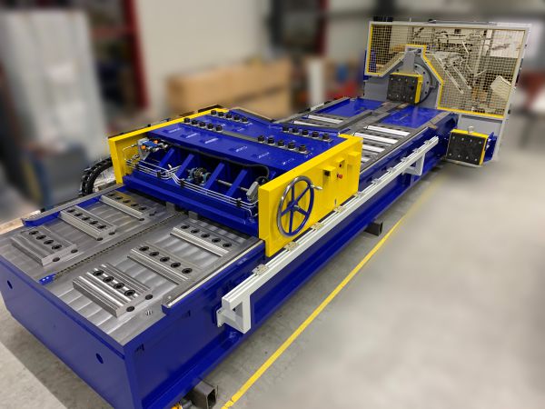 Blaue und gelbe horizontale Presse mit Rollenförderer und Schutzgitter in einer Werkhalle
