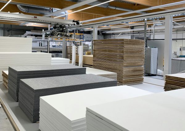 Gesamtansicht eines Flächenlagers mit mehreren Plattenstapeln unterschiedlicher Materialien. Das Portal-Handlingsystem ist oberhalb der Lagerplätze positioniert.