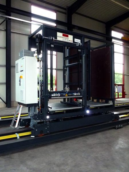 Schienenwagen mit Steuerungseinheit, stabiler Struktur und Laderampe in einer Industrieumgebung.