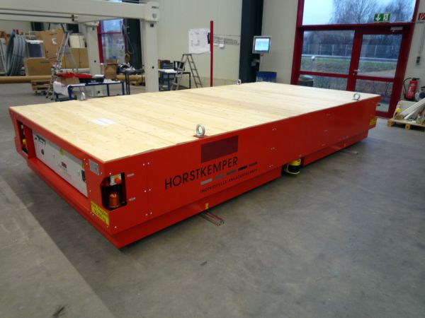 Robustes Flurförderfahrzeug in leuchtend rot mit Holzoberfläche und Sicherheitsleuchten