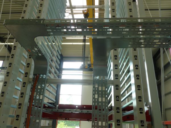 Blick in das Innere eines Sortierspeichers mit mehrgeschossigen Lagerfächern. Die Hub- und Transporteinheit befindet sich zwischen den Speicherreihen innerhalb der Anlage.