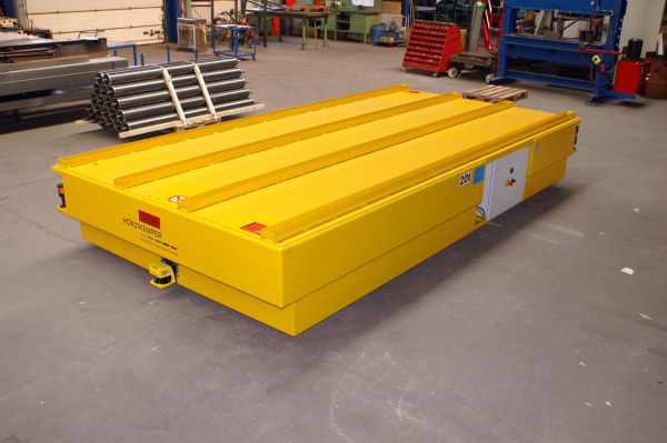 Gelbes Flurförderfahrzeug mit flacher Oberfläche, ideal zum Transport von schweren Lasten in Werkstätten.