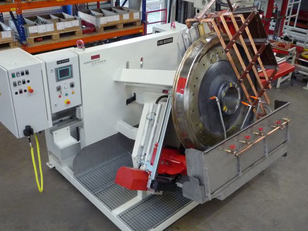 Schrägansicht eines Rissprüfstands mit eingespanntem Großwälzlagerring. Das Werkstück befindet sich in Prüfposition innerhalb der Spann- und Dreheinrichtung.