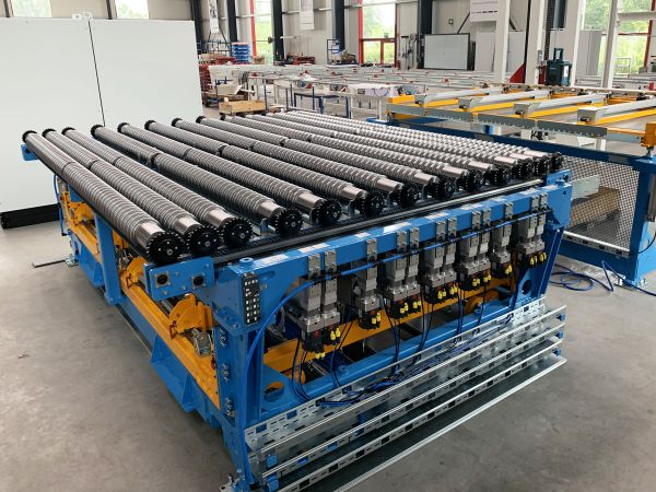 Schrägansicht einer Zentrierstation in Rüstposition. Die Rollenförderer und Zentrierelemente sind für die Aufnahme und Positionierung der Platinen vorbereitet.
