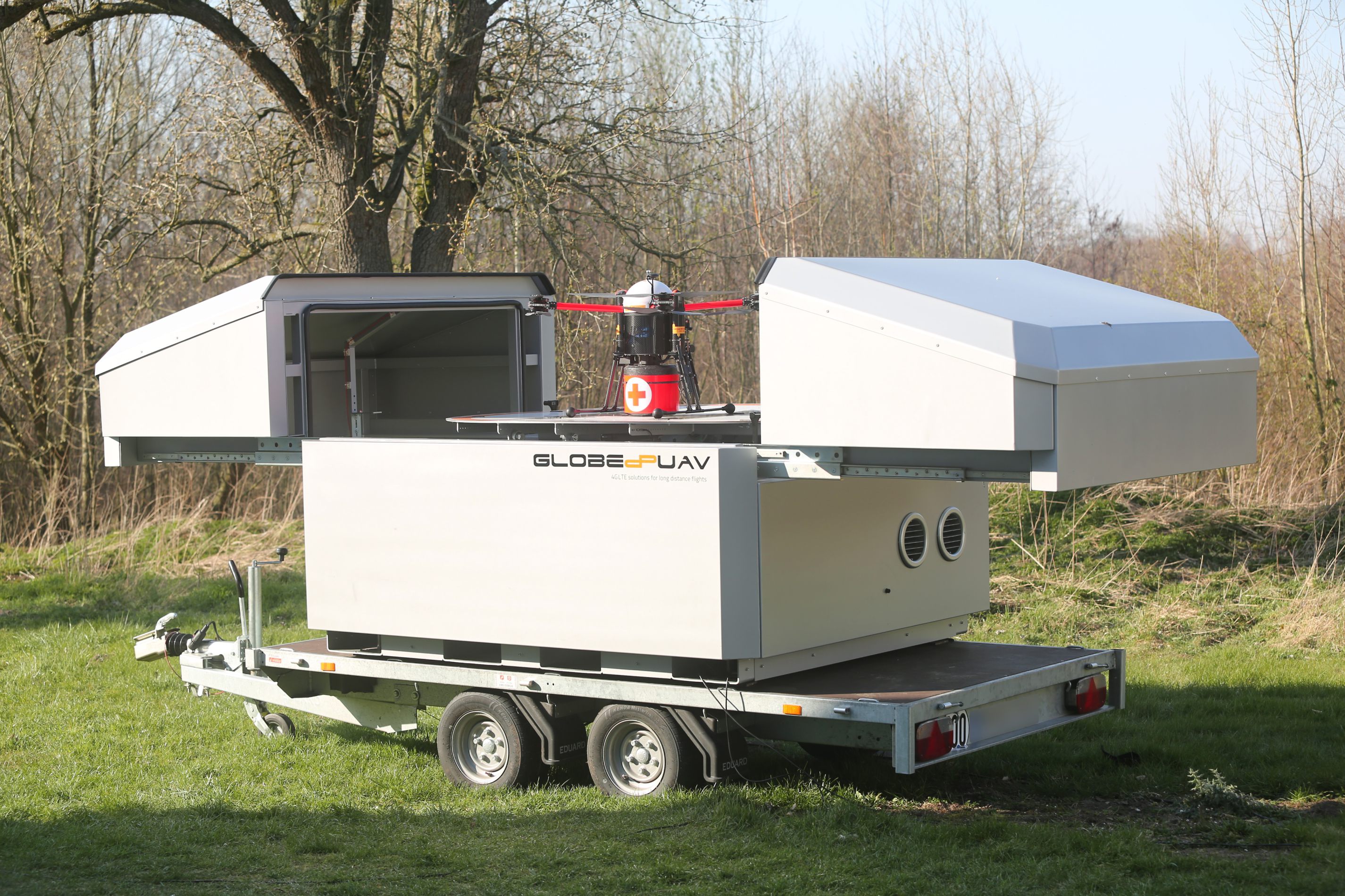 SkyPort mobile drone hangar with its doors open, on a trailer outdoors 