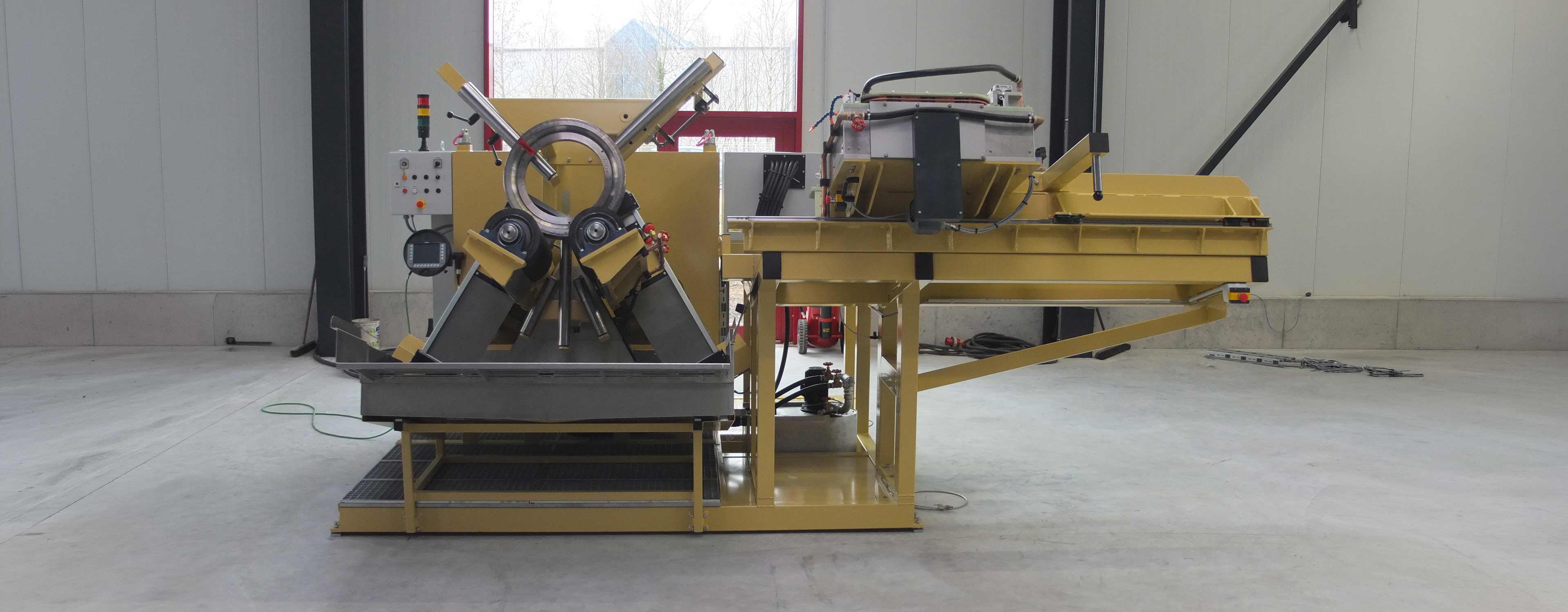 Front view of a crack test bench with a ring-shaped component clamped in place. The workpiece is positioned between the clamping rollers, while the testing and handling units are arranged on the sides.