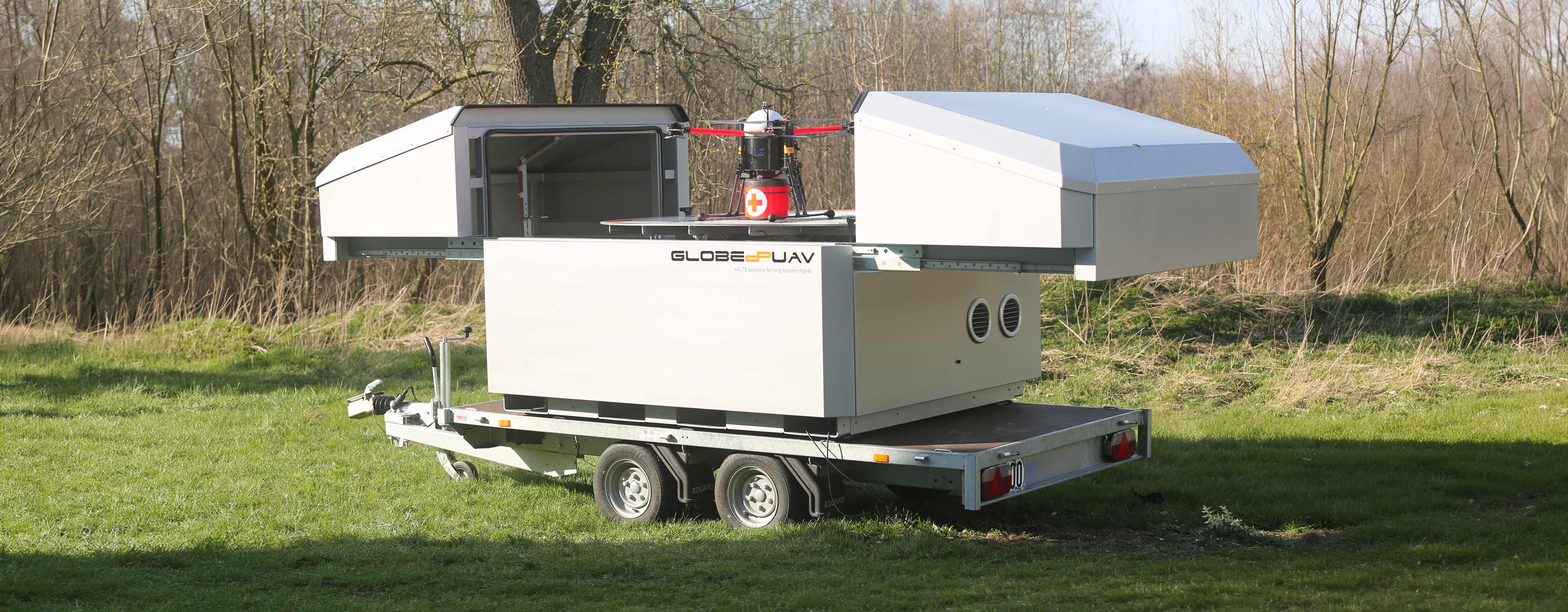 SkyPort mobile drone hangar with its doors open, on a trailer outdoors